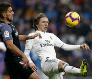 Luka Modric pelea por el control del balón contra Daniel Carrico. (AP)