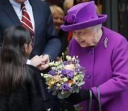 ARCHIVO – La reina Isabel II de Gran Bretaña recibe flores al salir tras la inauguración oficial en las nuevas instalaciones de los Hospitales Reales de Otorrinolaringología y Salud Dental Eastman en Londres el 19 de febrero de 2020.(Foto AP/Frank Augstein, archivo)