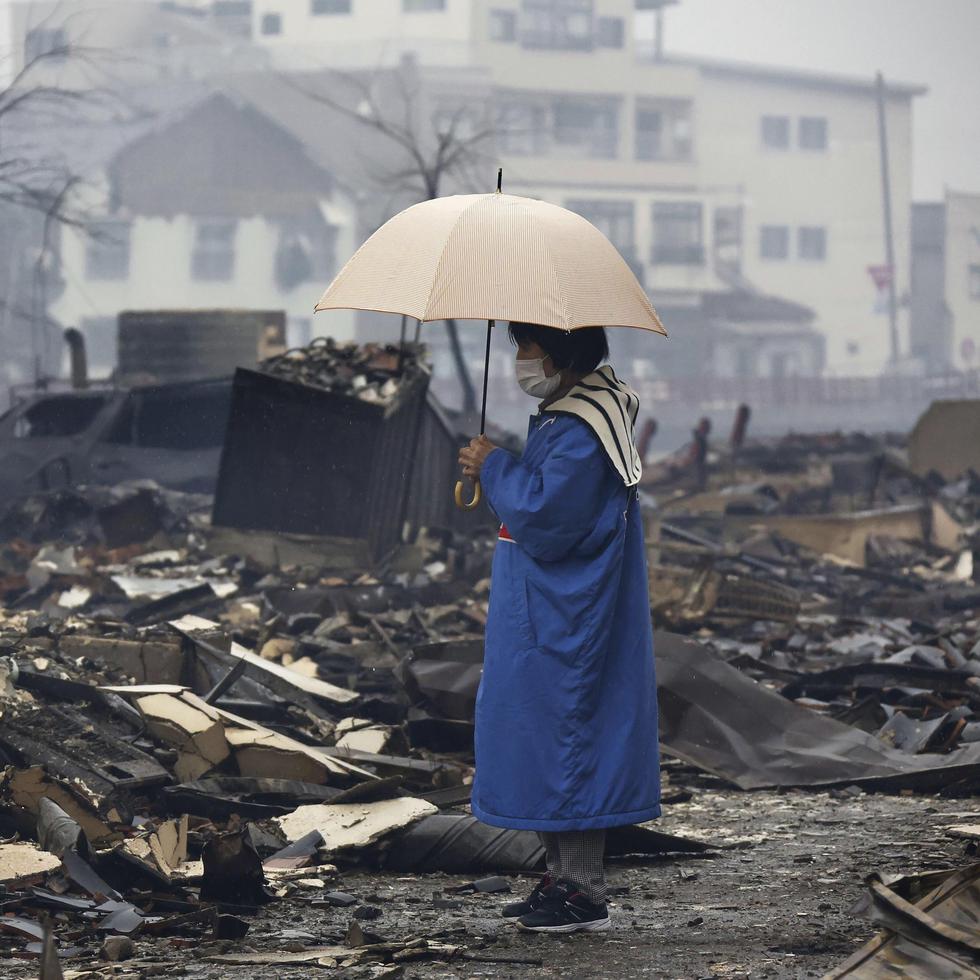 Una mujer observa el mercado quemado por un incendio tras los terremotos en Wajima, prefectura de Ishikawa, en Japón.