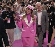 Este look fue un homenaje a la “Day to Night Barbie” del 1985. Margot Robbie a su llegada a la alfombra rosada en Seul lució un conjunto de traje de falda rosado de Versace, tacones blancos de punta rosada, sombrero blanco con una cinta rosada con lunares, un bolso rosado de Versace en forma de teléfono de Judith Leiber.
