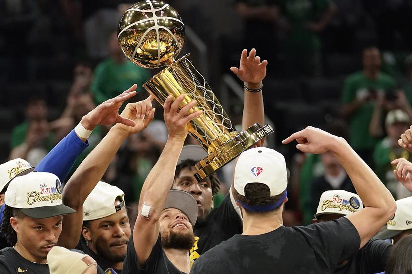 Stephen Curry alzan el trofeo de campeonato de la temporada 2021-22 de la NBA.
