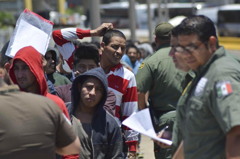 Agentes mexicanos verifican una lista de migrantes devueltos por la Patrulla Fronteriza a México en Nuevo Laredo, estado de Tamaulipas. (AP/Salvador González)