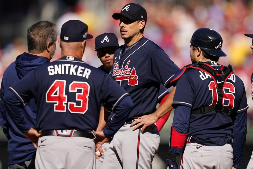 Braves manager Brian Snitker and the fitness trainer chat with pitcher Charlie Morton in the second inning of Saturday's game against Philadelphia.