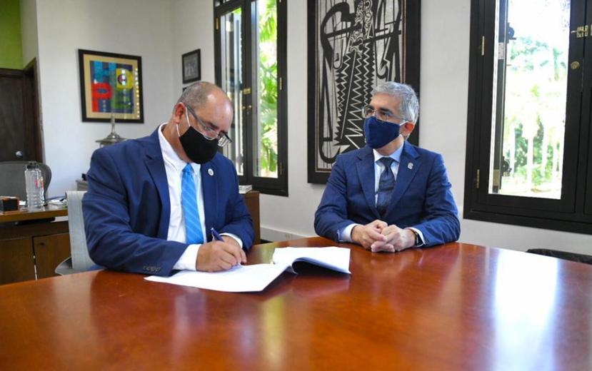 Desde la izq.: Carlos Flores, secretario de Agricultura, junto al rector del Recinto Universitario de Mayagüez, Agustín Rullán Toro, durante la firma del acuerdo en pro del café local.