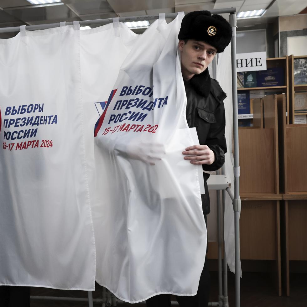 Un estudiante de la Universidad Marítima Estatal sale de una cabina de votación durante las elecciones presidenciales rusas, en la ciudad portuaria de Vladivostok.