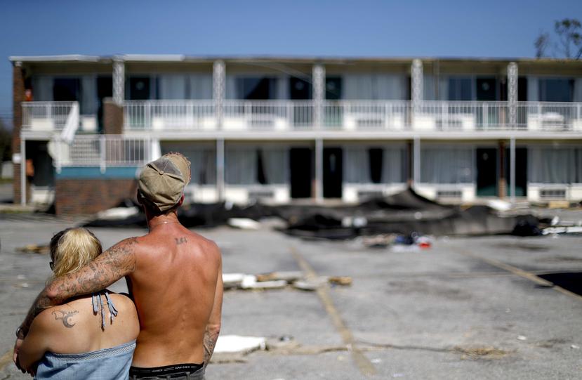 Resdientes observan un motel dañado. (AP)