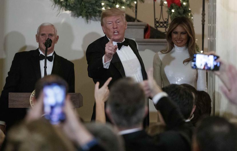 El presidente Donald Trump, con el vicepresidente Mike Pence y la primera dama Melania Trump, habla con los asistentes a la fiesta del Congreso en el Gran Foyer de la Casa Blanca en Washington el sábado 15 de diciembre de 2018. (AP)