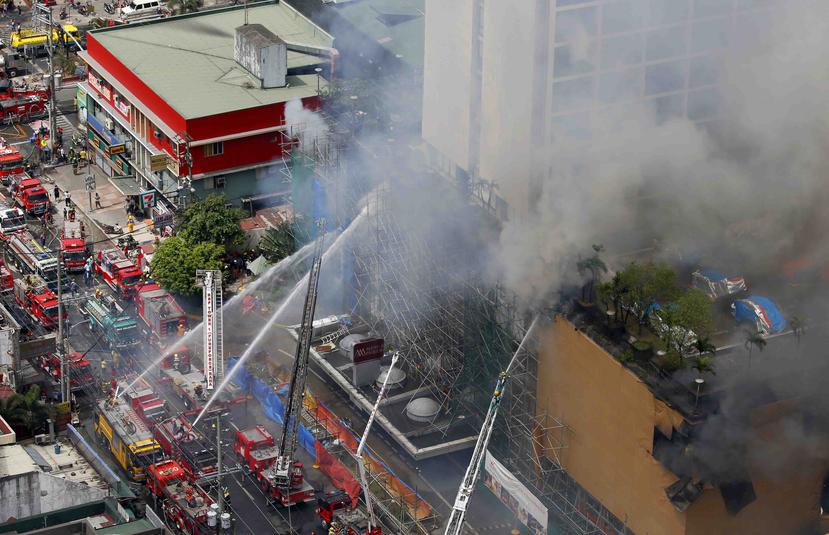 Los bomberos combaten las llamas en el Manila Pavilion Hotel and Casino en Manila, Filipinas. (AP)