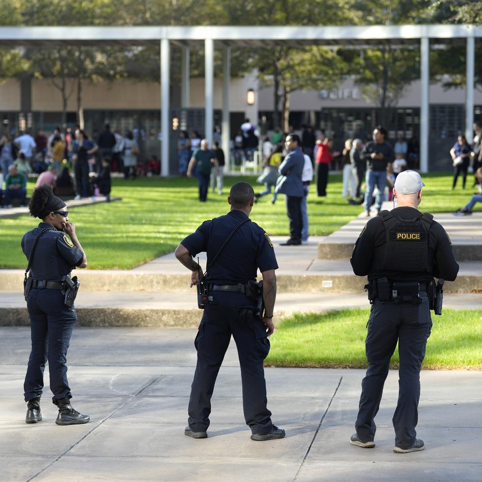 Oficiales de la Policía de Houston Police observan a los feligreses que salen de la Lakewood Church tras un ataque a tiros reportado durante el servicio dominical en español.