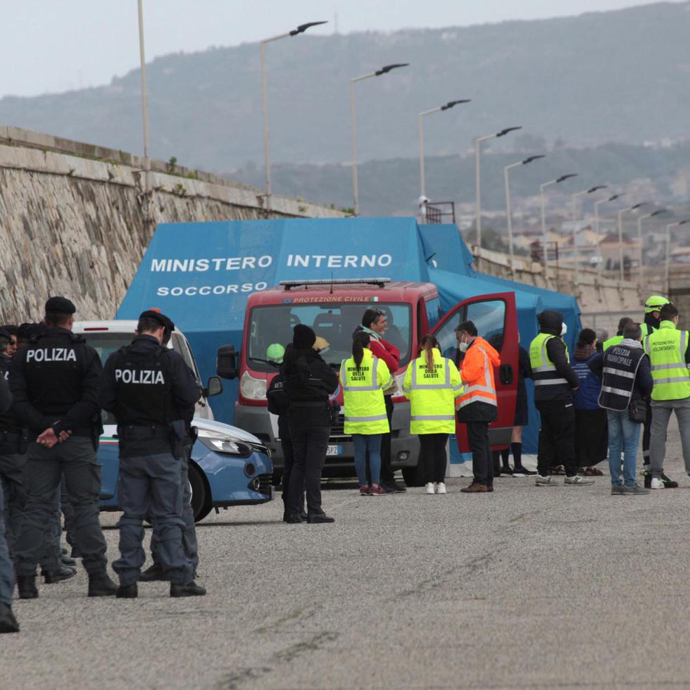 Agentes de la policía italiana atienden a inmigrantes rescatados en el Mediterráneo este sábado en las costas del país.
EFE/EPA/MARCO COSTANTINO