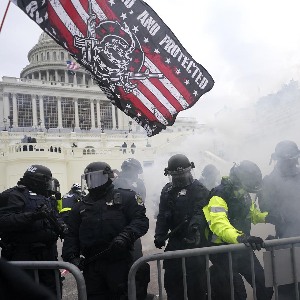 Policías se enfrentan a violentos partidarios del entonces presidente Donald Trump, quienes intentan abrirse paso a través de una barricada policial, el 6 de enero de 2021, en el Capitolio, en Washington. (AP Foto/Julio Cortez, Archivo)