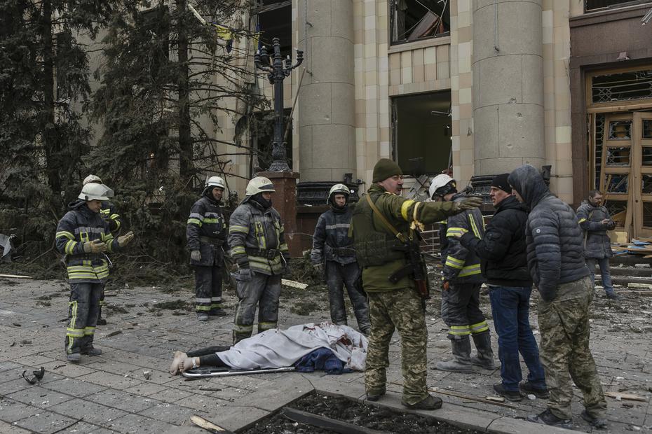 Personal de los servicios de emergencia ucranianos y militares rodean el cuerpo de una víctima tras el bombardeo del edificio del Ayuntamiento en Kharkiv, Ucrania, el martes 1 de marzo de 2022. 