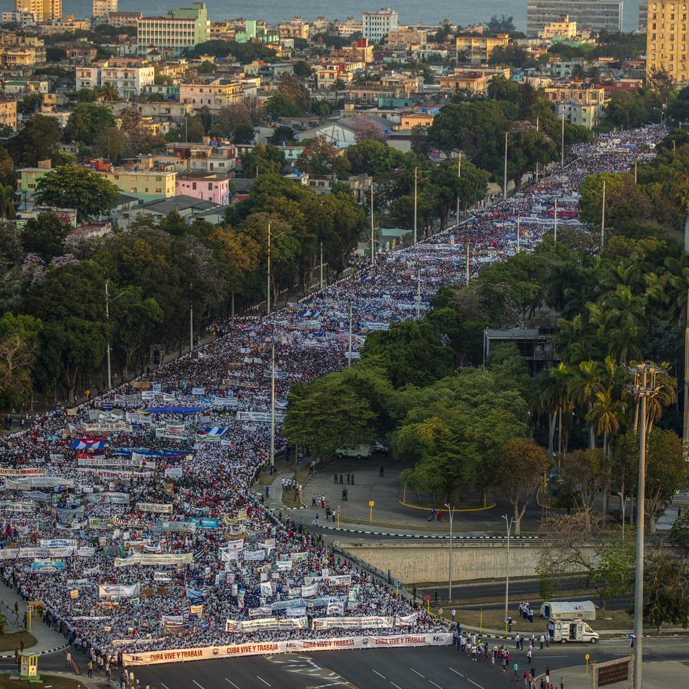 Miles de personas desfilan por una avenida durante la marcha del 1 de Mayo hacia la Plaza de la Revolución en La Habana, Cuba.