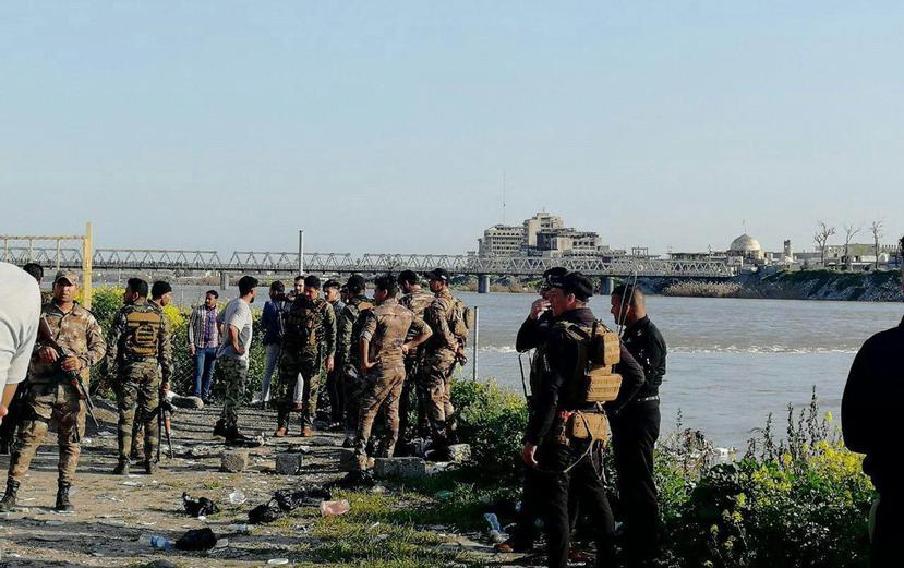 Varios soldados inspeccionan el lugar donde un barco naufragó por exceso de pasajeros en el río Tigris, en Mosul, Irak. (EFE)