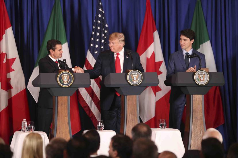 El presidente mexicano, Enrique Peña Nieto, le estrecha la mano a Donald Trump, mientras el líder de Canadá,  Justin Trudeau, observa. (AP)