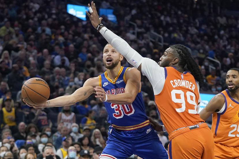 Stephen Curry (30) intenta anotar pese a defensa del delantero Jae Crowder (99) de los Suns de Phoenix en un juego en San Francisco.