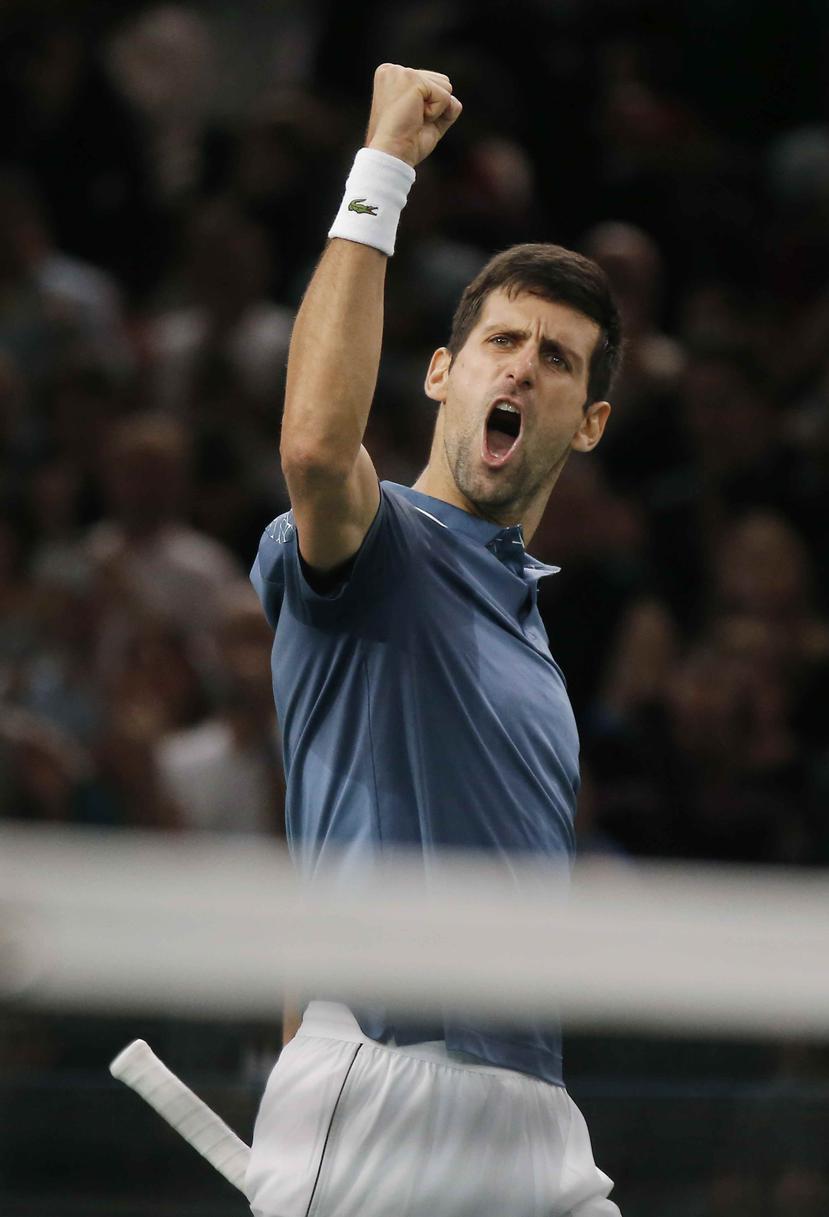 Novak Djokovicv alza el puño en celenbración tras vencer a Roger Federer en una semifinal del Masters de París. (AP)