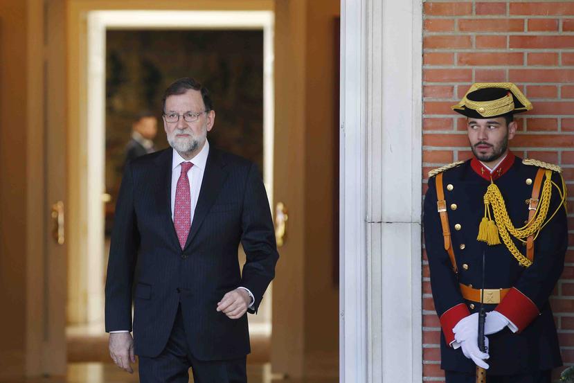 Un guardia mira al jefe de gobierno Mariano Rajoy en el Palacio de la Moncloa en Madrid, España. (AP)