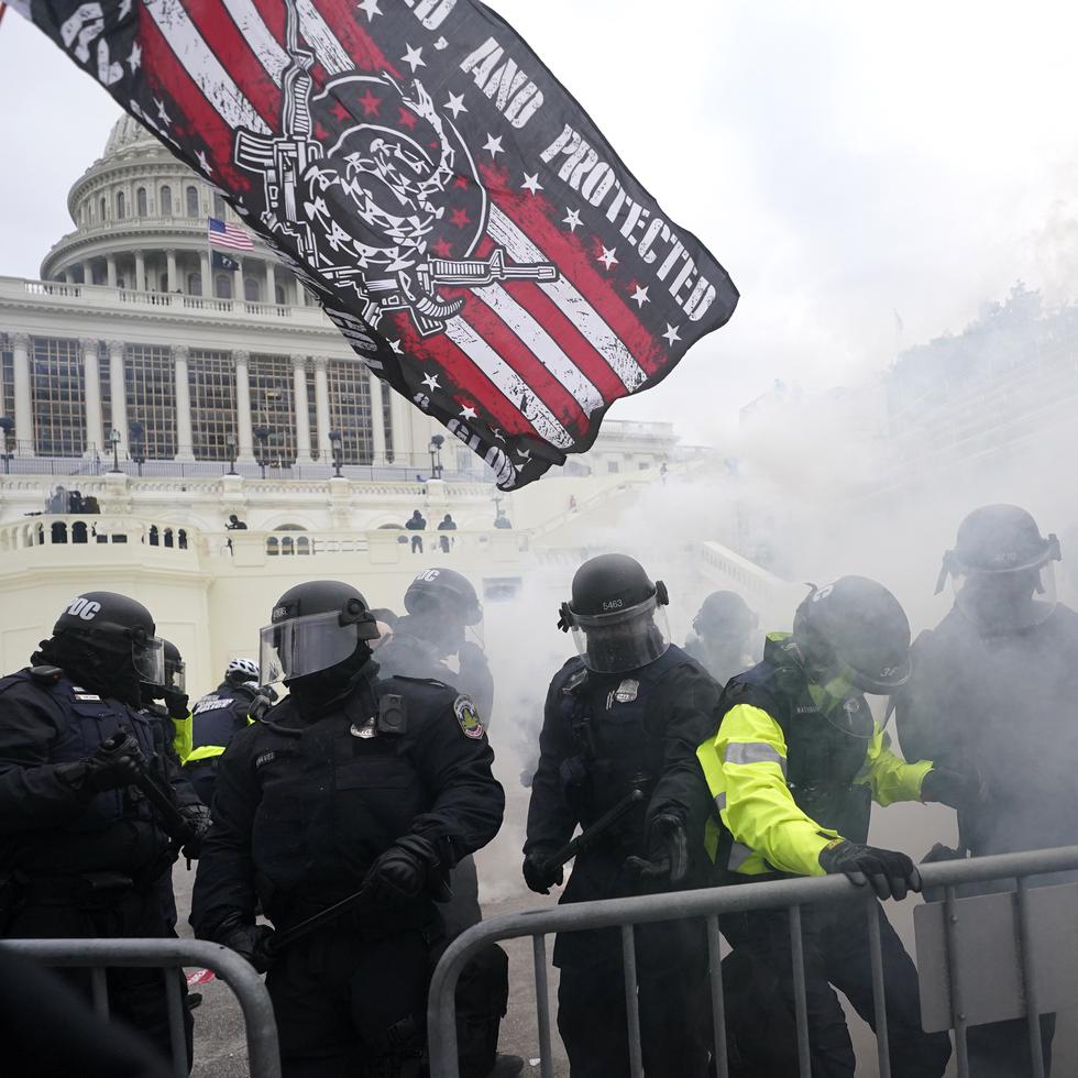 Policías se enfrentan a violentos partidarios del entonces presidente Donald Trump, quienes intentan abrirse paso a través de una barricada policial, el 6 de enero de 2021, en el Capitolio, en Washington. (AP Foto/Julio Cortez, Archivo)