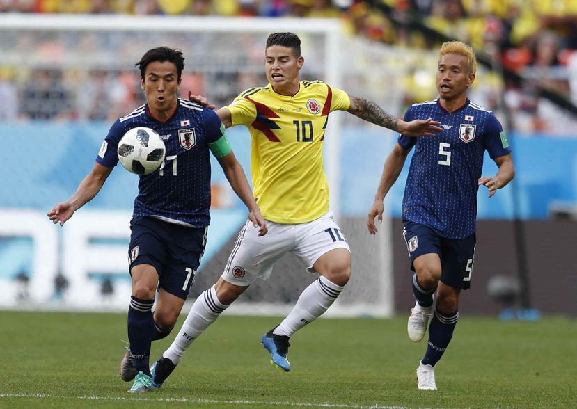 James Rodríguez persigue la pelota junto a los japoneses. (AP)
