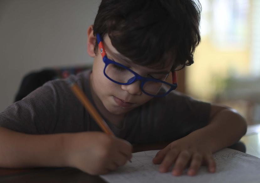 En la foto, Lucas Iré Araújo Canino, de seis años, trabaja la escritura y la suma.