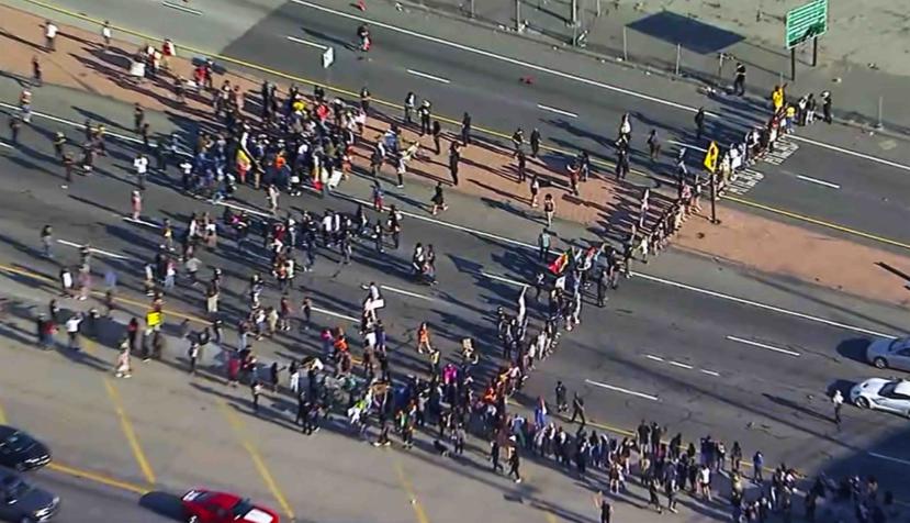 Esta imagen facilitada por la cadena KABC-TV muestra a numerosos manifestantes del movimiento Black Lives Matter (Las vidas de los negros importan) mientras bloquean una carretera el miércoles 27 de mayo de 2020 en el centro de Los Ángeles. (AP)