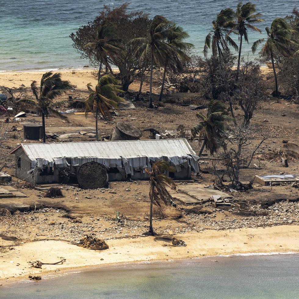 En esta imagen proporcionada por la Fuerza Australiana de Defensa, restos de un edificio dañado y árboles derribados en la isla de Atata en Tonga el 28 de enero de 2022, tras la erupción de un volcán submarino y un tsunami.