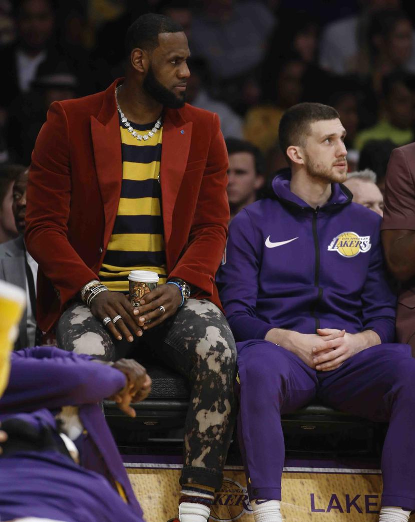 Vestido en ropa casual tras una lesión en la ingle, LeBron James observa desde la banca la primera mitad del partido entre los Lakers de Los Ángeles y los Kings de Sacramento, durante el día de su cumpleaños. (AP)