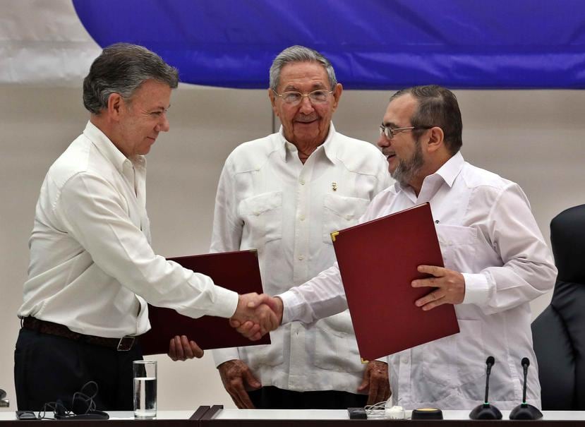 Rodrigo Londoño Echeverri, alias "Timochenko" (der.) y el presidente de Colombia, Juan Manuel Santos junto a el presidente de Cuba, Raúl Castro durante los diálogos de paz en Cuba. (EFE)