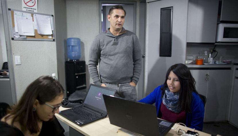 César Batiz, director de El Pitazo (centro), junto a dos periodistas en la redacción de la popular plataforma digital en Caracas, Venezuela. (AP)