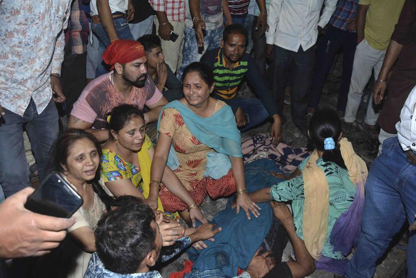 Familiares de una de las víctimas que fueron atropelladas por un tren en las afueras de Amritsar, en el estado de Punjab, en India, lloran a su ser querido al lado de su cadáver. (AP)