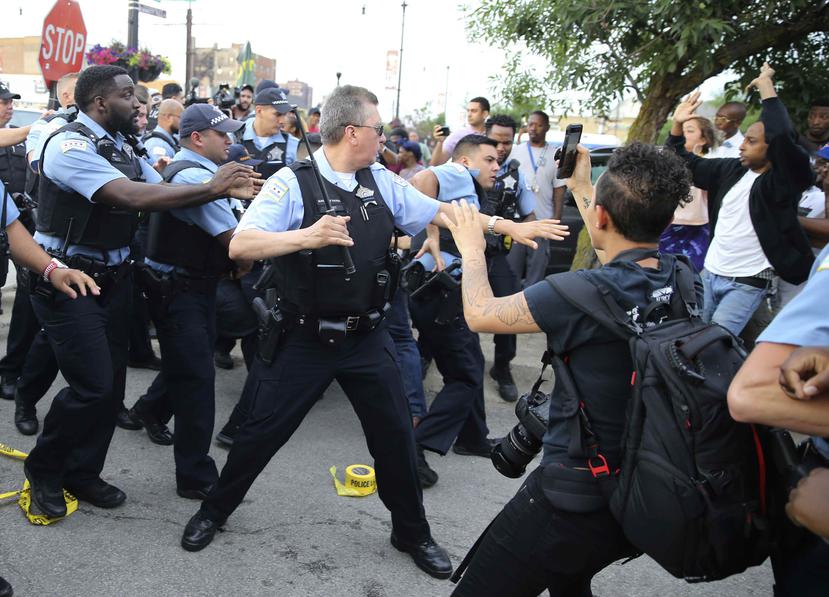 Agentes del Departamento de Policía de Chicago confrontan a una multitud enargdecida tras la muerte a tiros de un hombre a manos de agentes en Chicago, el sábado 14 de julio de 2018. (AP)