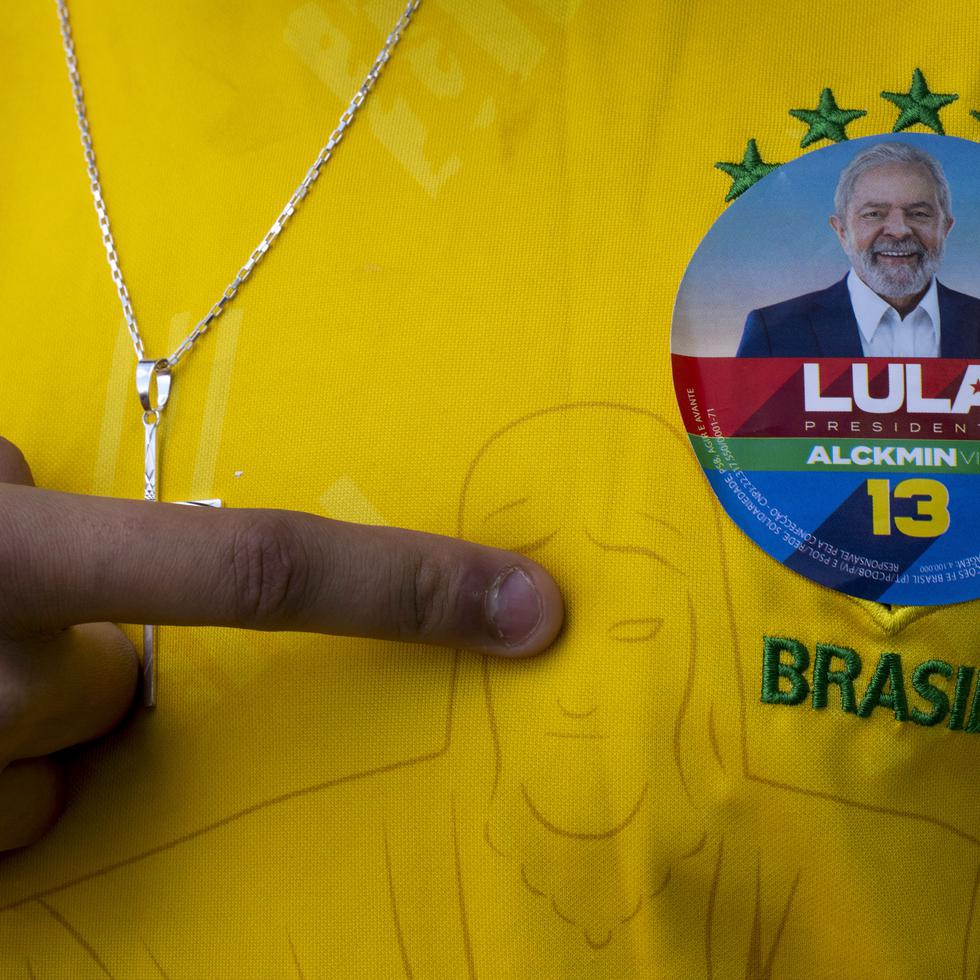 A man wearing a Brazil jersey with a sticker of former Brazilian President Luiz Inacio "Lula" da Silva, who is running for president, poses for a photo during general elections, in Acegua, Brazil, Sunday, Oct. 2, 2022. (AP Photo/Matilde Campodonico)