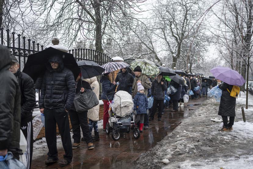 Decenas de ciudadanos en la capital ucraniana de Kiev hacen fila para recolectar agua potable.