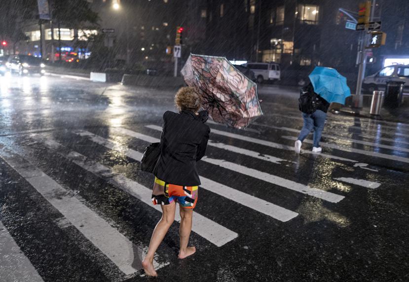 Peatones cerca del Columbus Circle, a pasos de Central Park, intentan cubrirse de las lluvias.