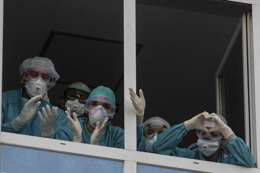 Trabajadores de salud aplauden y agradecen desde el balcón en Madrid ante el apoyo de la ciudadanía por su labor durante la emergencia. (AP)