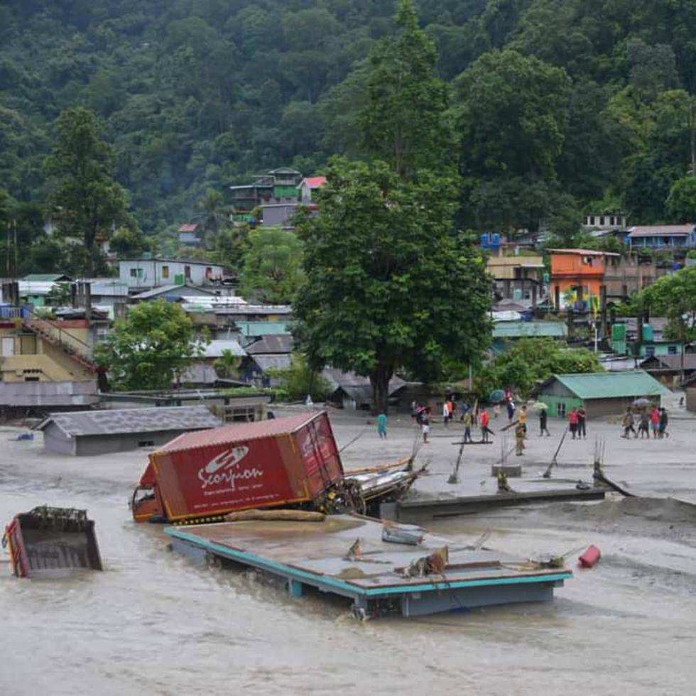 Un vehículo fue arrastrado por la crecida junto a un edificio anegado por las inundaciones repentinas registradas en la región Sikkim, en India.