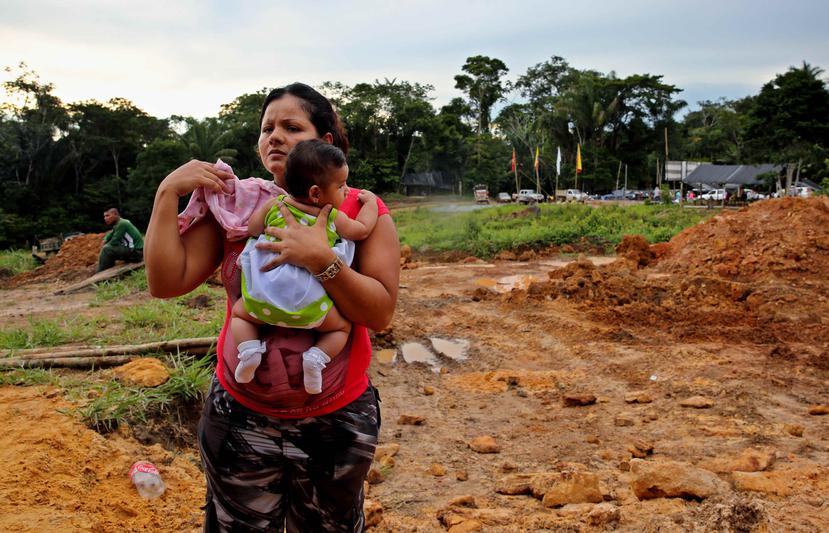 Una mujer integrante de las FARC sostiene a su hija en la celebración del Día de las Madres en la Zona Veredal de "Las Colinas" en Guaviare, Colombia. (EFE)