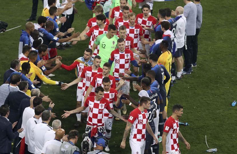 Los jugadores croatas chocan manos con el onceno francés al concluir el partido de campeonato de la Copa Mundial. (AP / Thanassis Stavrakis)