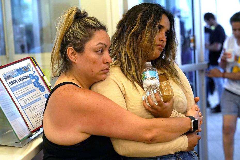 Andrea and Nellie Gonzalez esperan por noticias de sus familiares en el Centro de Reunificación familiar establecido cerca al área del colapso.