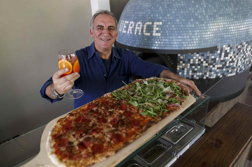 El restaurantero Alessandro Calenda muestra su pizza Metro, más grande y que se puede dividir en sabores para complacer los gustos de toda la familia. (david.villafane@gfrmedia.com)