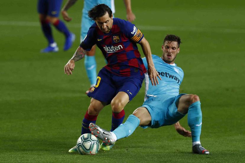 Lionel Messi batalla por el balón contra Rubén Pérez. (AP)
