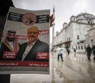 Un hombre sostiene un cartel que muestra imágenes del príncipe heredero saudí Mohammed bin Salman y del periodista Jamal Khashoggi, en el que se describe al príncipe como "asesino" y a Khashoggi como "mártir" durante un momento de oración por Khashoggi.