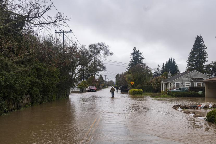 Un hombre camina por una calle inundada el viernes 10 de marzo de 2023, en Watsonville, California. (AP Foto/Nic Coury)
