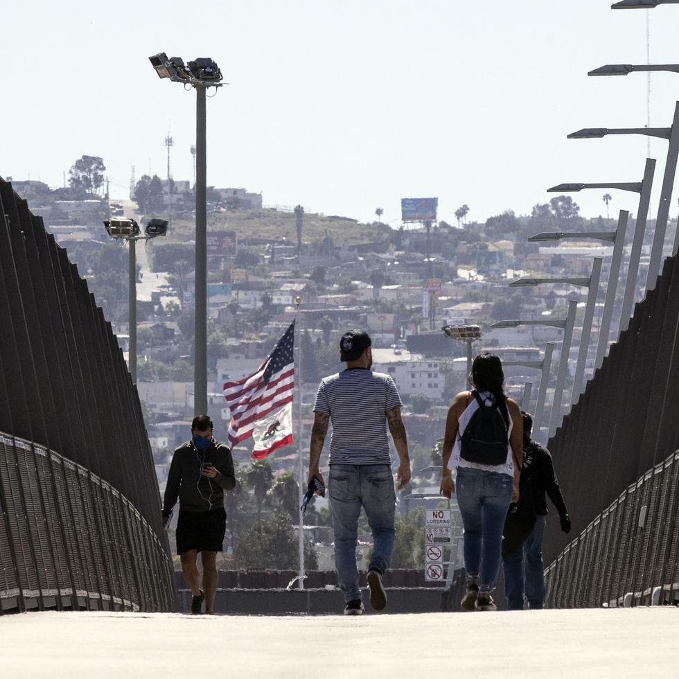 Inmigrantes cruzan un puente desde México hacia Estados Unidos, en una fotografía de archivo.