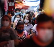 Shoppers, wearing protective face masks as a precaution against the spread of the new coronavirus, fill a local market in Asuncion, Paraguay, Tuesday, May 5, 2020. The government authorized the reopening of some businesses under a plan coined, "intelligent quarantine”. (AP Photo/Jorge Saenz)