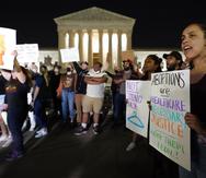 Una multitud de personas se reúne frente al Tribunal Supremo durante la madrugada del 3 de mayo de 2022 en Washington, D.C.