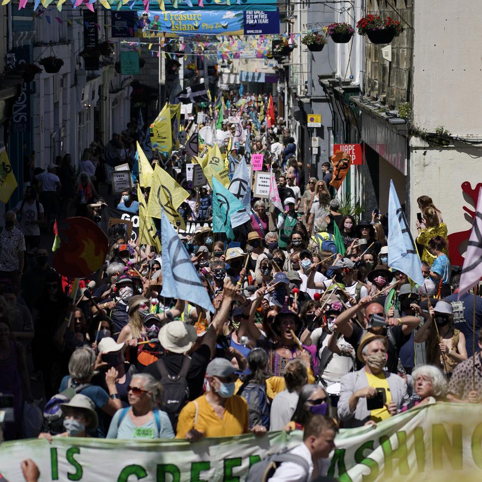 Activistas marchan por las calles de Falmouth, Inglaterra durante una manifestación en el marco de la reunión del G7.