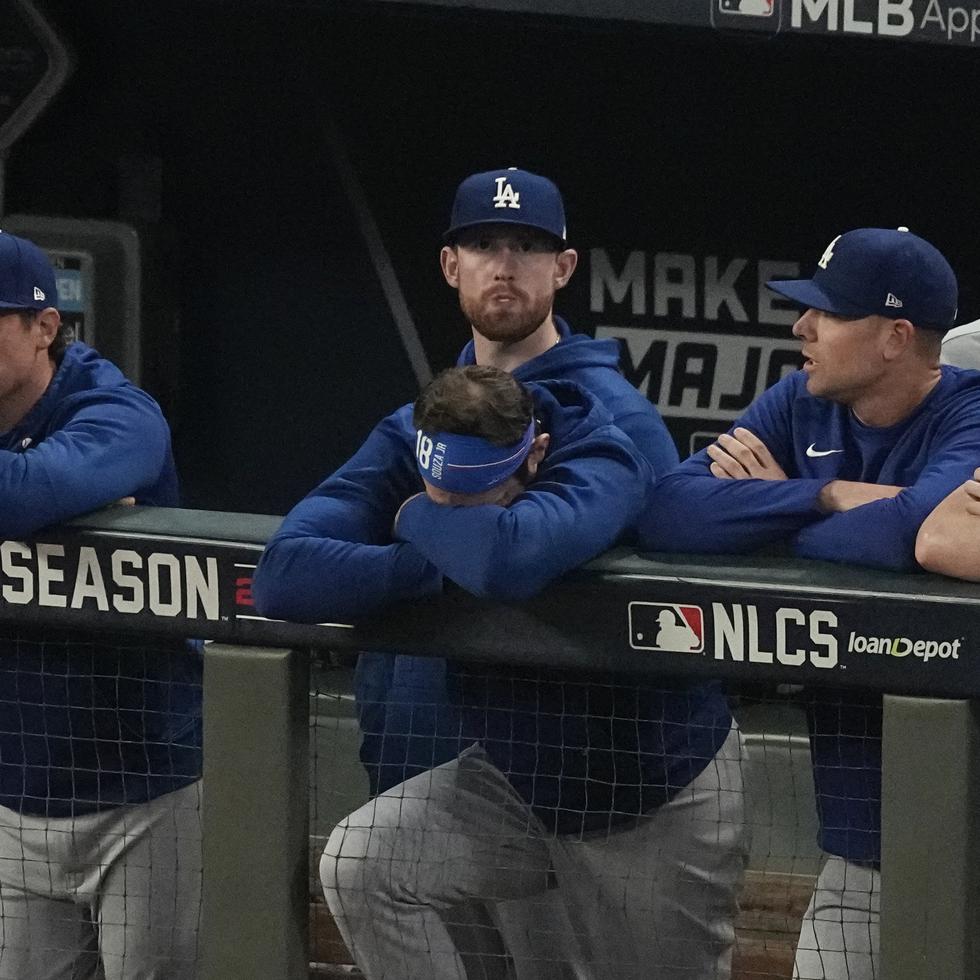 Integrantes de los Dodgers miran desde el dugout la novena entrada del partido de anoche.