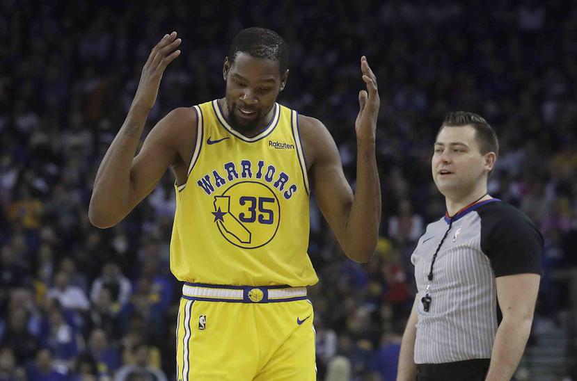 Kevin Durant, de los Warriors de Golden State, hace un gesto junto al árbitro Gediminas Petraitis, durante el partido ante los Nuggets de Denver. (AP)